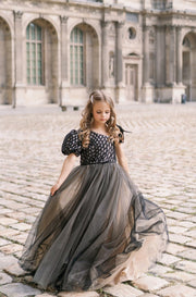 Long, contrasting black and beige girls' elegant tulle dress. Long a-line tulle skirt, asymmetrical sleeves, and ribbon detail. For special occasions: Wedding, Birthday party, Prom, Flower girl, Eid, and other events.