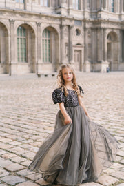 Long, contrasting black and beige girls' elegant tulle dress. Long a-line tulle skirt, asymmetrical sleeves, and ribbon detail. For special occasions: Wedding, Birthday party, Prom, Flower girl, Eid, and other events.