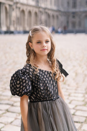 Long, contrasting black and beige girls' elegant tulle dress. Long a-line tulle skirt, asymmetrical sleeves, and ribbon detail. For special occasions: Wedding, Birthday party, Prom, Flower girl, Eid, and other events.
