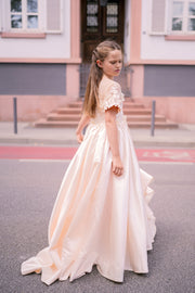 Long, princess ball gown in a soft vanilla-creme color, with a long, voluminous satin skirt, satin top with short sleeves, 3D floral embroidery and mesh details. Handmade with love. Occasions: Wedding, Birthday party, Prom, Flower girl, Eid, and other events.