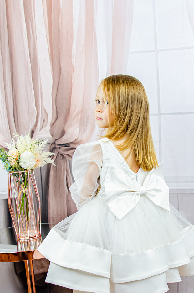 Handmade short white flower girl's dress with a multi-layered tutu skirt, golden embroidery and a big bow on the back