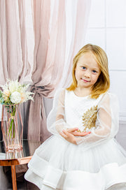 Handmade short white flower girl's dress with a multi-layered tutu skirt, golden embroidery and a big bow on the back