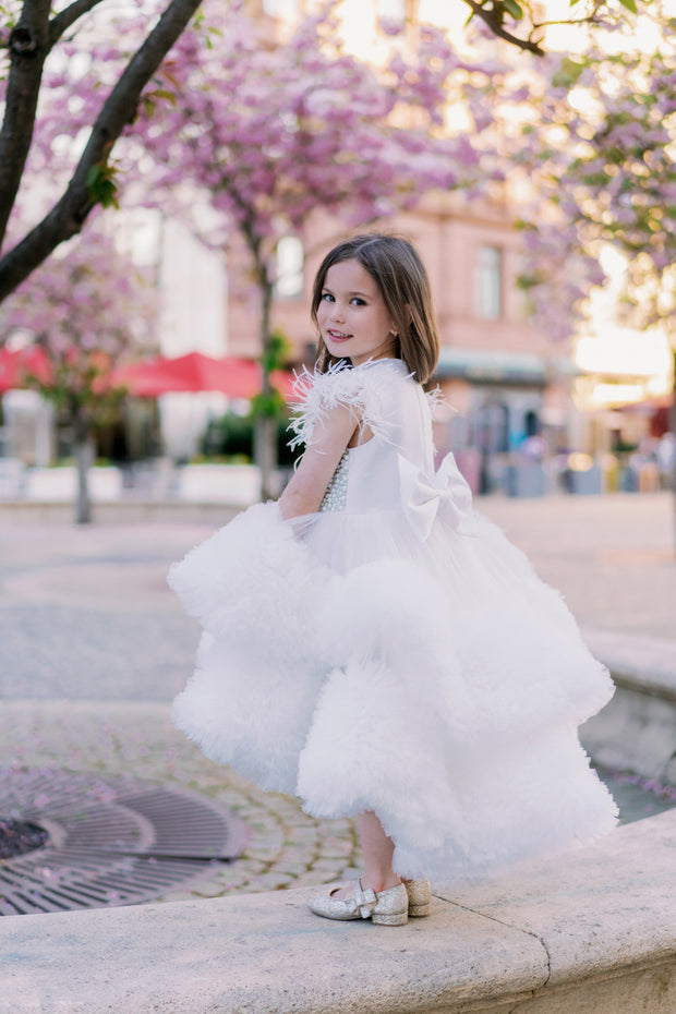 White, asymmetrical girl dress with a voluminous, ruffle tulle skirt, feather details and pearl embellished top. Occasions: Wedding, Birthday party, Flower girl, Communion, Eid and other events.