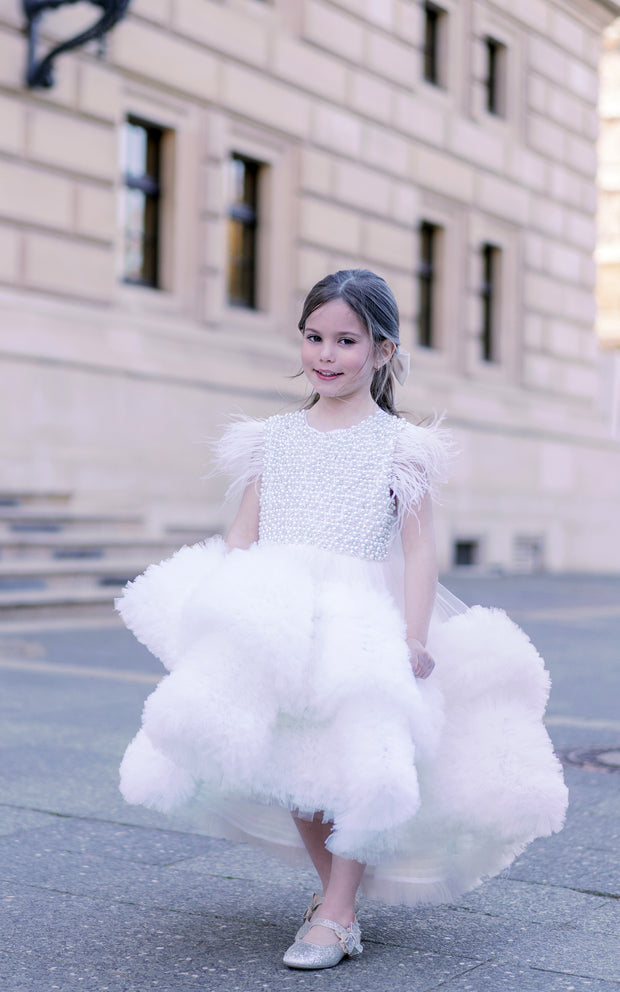 White, asymmetrical girl dress with a voluminous, ruffle tulle skirt, feather details and pearl embellished top. Occasions: Wedding, Birthday party, Flower girl, Communion, Eid and other events.