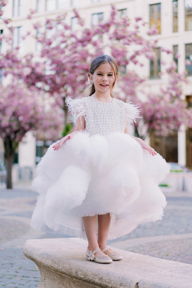 White, asymmetrical girl dress with a voluminous, ruffle tulle skirt, feather details and pearl embellished top. Occasions: Wedding, Birthday party, Flower girl, Communion, Eid and other events.