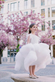 White, asymmetrical girl dress with a voluminous, ruffle tulle skirt, feather details and pearl embellished top. Occasions: Wedding, Birthday party, Flower girl, Communion, Eid and other events.
