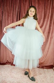 Ankle-length tulle girl dress with a multi-layered tulle skirt, tulle pleated top with a high collar and pearl embellishments along the neckline and the waistline. Princess girl dress for a girl birthday party, flower girl dress, wedding, communion.