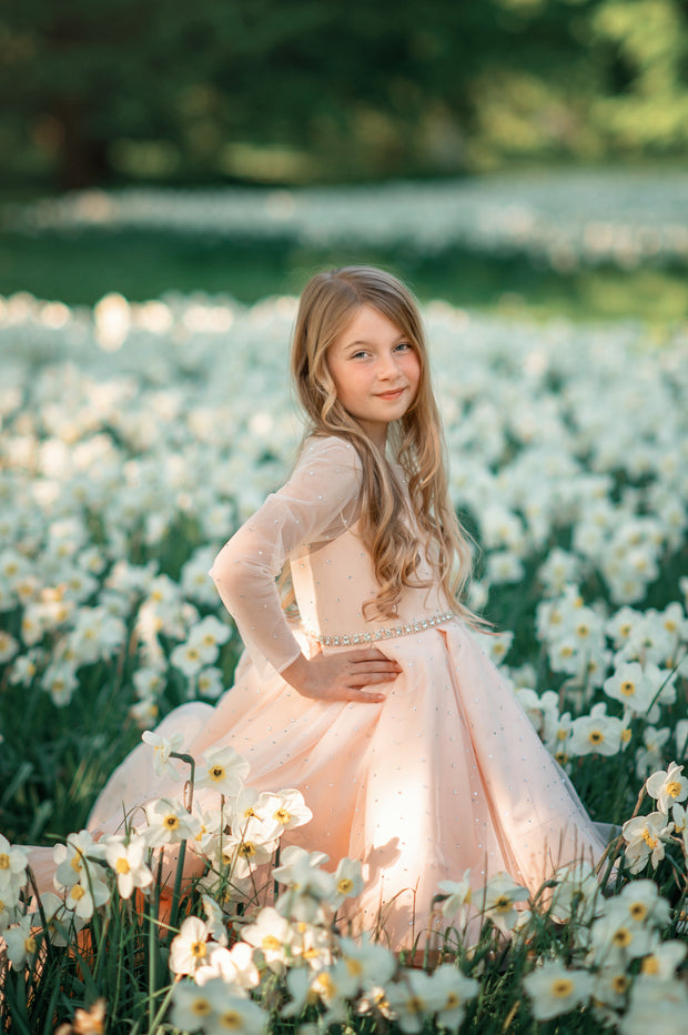 Sparkly high-low hemline girl dress with a satin skirt, satin train, long tulle sleeves and all-over rhinestone embellishments.