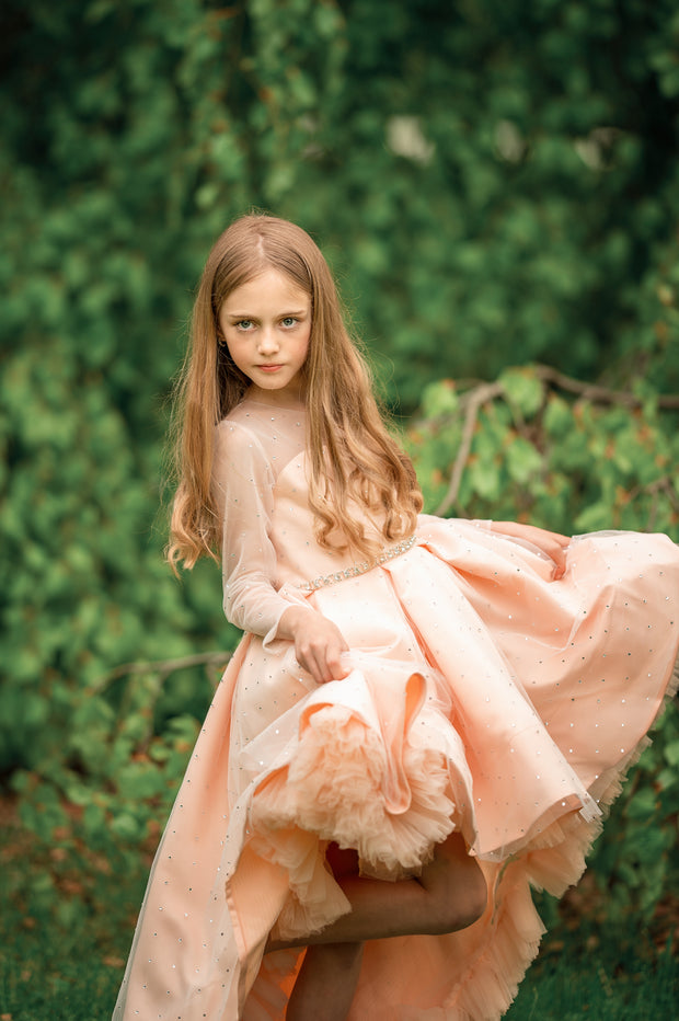 Sparkly high-low hemline girl dress with a satin skirt, satin train, long tulle sleeves and all-over rhinestone embellishments.