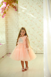 Knee-length princess girl dress with a voluminous, multi-layered tulle skirt, long, transparent tulle sleeves and satin top embroidered with pastel coloured flowers. For special occasions: Wedding, Birthday party, Prom, Flower girl, Eid, and other events.