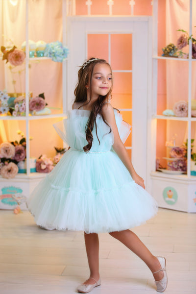 Knee-length elegant girl dress in a light blue colour with a voluminous tulle skirt and top embellished with a pearl ribbon at the waistline. For special occasions: Wedding, Birthday party, Prom, Flower girl, Eid, and other events.