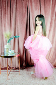 Asymmetrical high-low hem girl princess dress in bright pink with a multi-layer tulle skirt, satin top, open back and a pink bow.