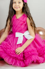 Bright pink baby girl festive dress with tulle skirt and white sequin bow. The dress is for holiday season, Christmas, New Year, weddings, Eid, birthdays, parties, flower girls and other special formal events and occasions.