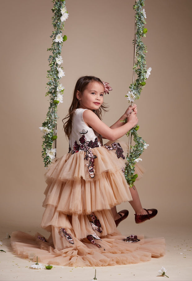 custom made, personalised girl dress in beige with a high-low hem, multi-layered tulle skirt and sequin embroidery in gold and red