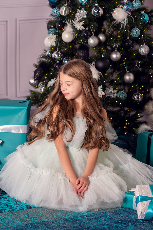 Festive knee-length elegant girl dress in a light blue colour with a voluminous tulle skirt and top embellished with a pearl ribbon at the waistline. For special occasions: Christmas, New Year, Wedding, Birthday party, Prom, Flower girl, Eid, and other events.