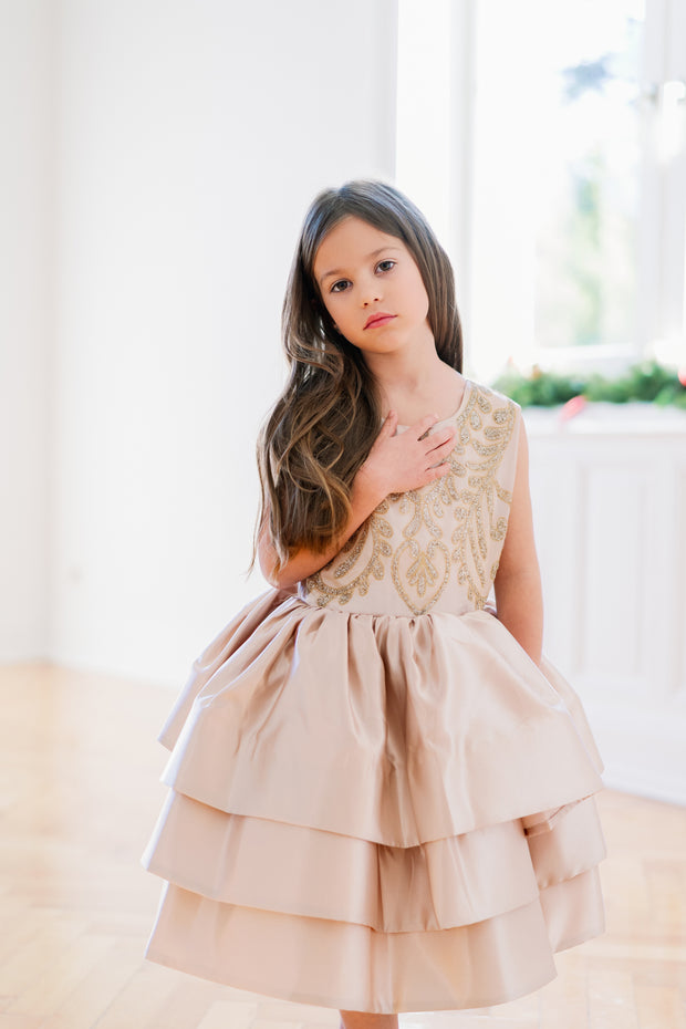 Knee-length satin girl dress in a gold colour. The dress features an a-line satin skirt with tulle underskirt which gives it volume. Satin top with high neckline is accentuated with gold embroidery. For special occasions: Wedding, Birthday party, Prom, Flower girl, Eid and other events.
