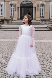 Long, a-line tulle boho style first communion, flower girl dress in white with long tulle skirt and lace details, high collar, buttons at the back and long transparent sleeves with lace details. Handmade with love. Occasions: First Communion, Flower girl, Wedding, Birthday party, and other events.