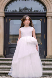 Long, a-line flower girl tulle dress in white with long, asymmetrical tulle skirt and sleeveless pleated tulle top. Handmade with love. Occasions: First Communion, Flower girl, Wedding, Birthday party, and other events. 