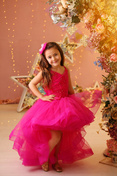 Festive bright pink girl dress with high-low hem, long tulle train and floral embroidery. The dress is for holiday season, Christmas, New Year, weddings, Eid, birthdays, parties, flower girls and other special formal events and occasions.