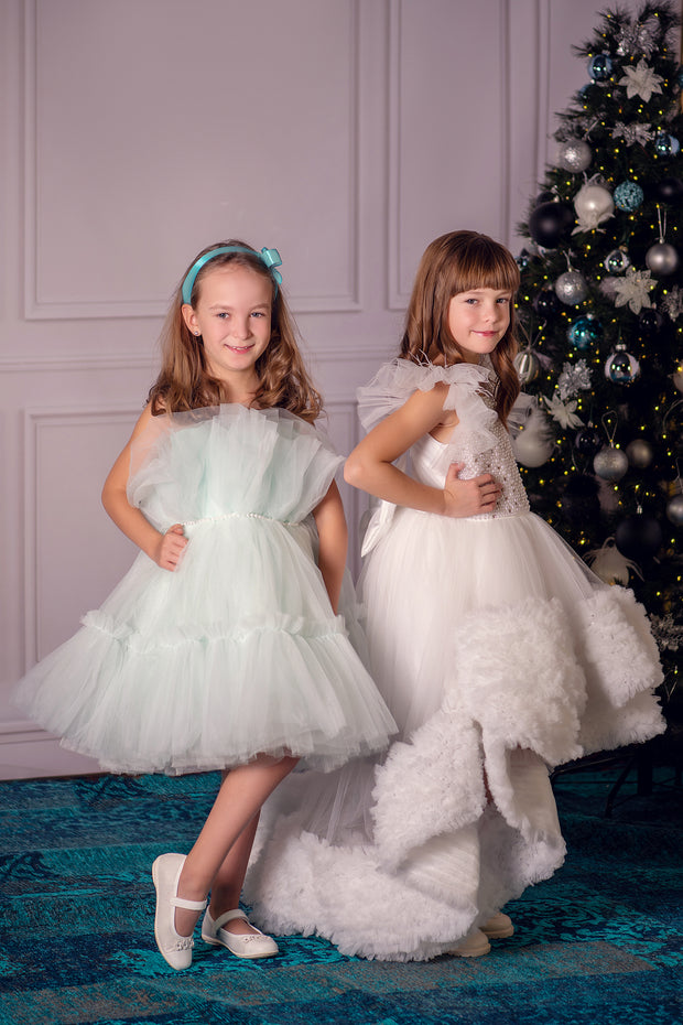 Festive, white, asymmetrical girl dress with a voluminous, ruffle tulle skirt, feather details and pearl embellished top. Occasions: Christmas, New Year's Eve, Wedding, Birthday party, Flower girl, Communion, Eid and other events.