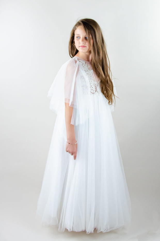 Floor-length white tulle princess dress with a floating tulle skirt, transparent butterfly sleeves and transparent bodice covered with embellished flower details and pearls. Girl dress for flower girls, weddings, communion or birthday party.