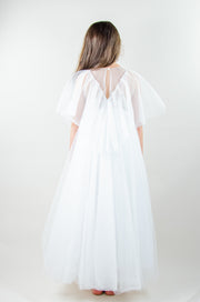 Floor-length white tulle princess dress with a floating tulle skirt, transparent butterfly sleeves and transparent bodice covered with embellished flower details and pearls. Girl dress for flower girls, weddings, communion or birthday party.