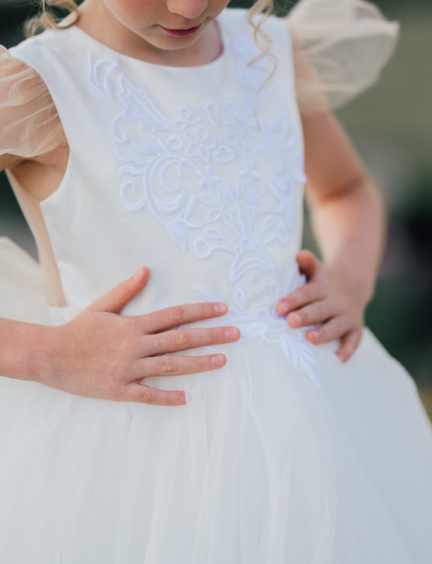 Long flower girl dress in white with a long, tulle train, lace embroidery, open back with lace and a big bow. For special occasions: Wedding, Birthday party, Prom, Flower girl, Eid, and other events.