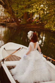 Enchanting fairy tale princess look with a long, white ball gown with voluminous skirt with tulle ruffles and open back. Occasions: Wedding, Birthday party, Prom, Flower girl, Eid, and other events.