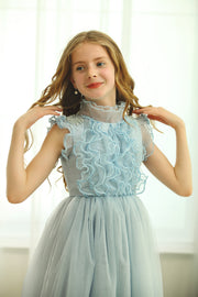 Ankle-length baby blue dress with sleeveless ruffled top, transparent high collar, and pearl embellishments from shoulders down to the open back. Girl dress for flower girls, weddings, birthdays and other special occasions.