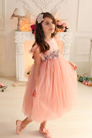 girl in pastel pink dress with multi-layer tulle skirt and floral embellishment