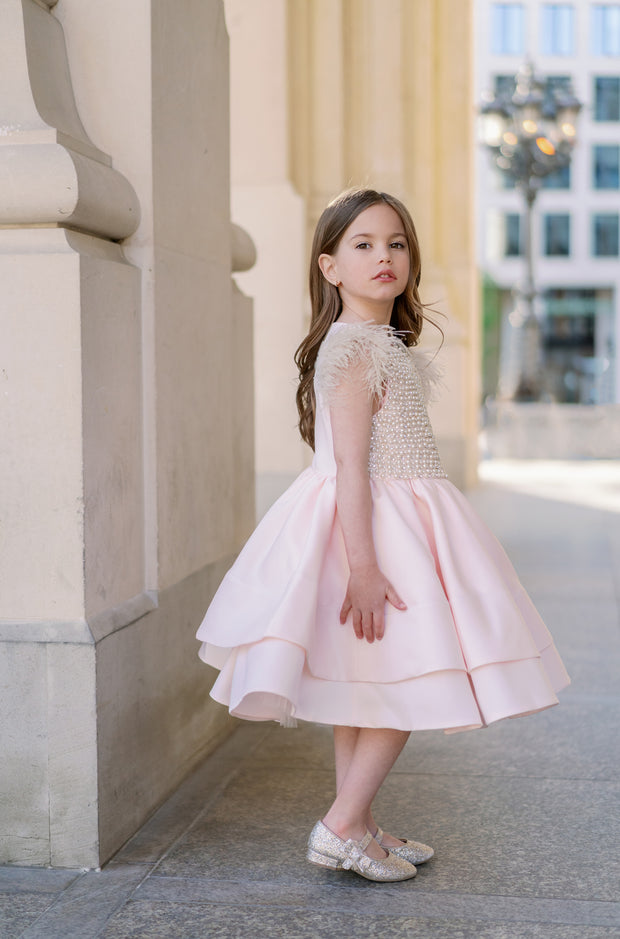 Midi satin girl dress in light apricot colour with a multi-layered satin skirt, short sleeves with feather details and satin top embellished with pearls.