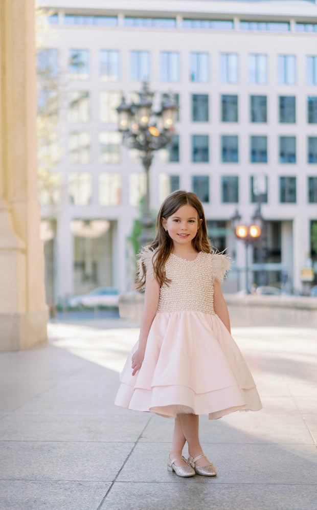 Midi satin girl dress in light apricot colour with a multi-layered satin skirt, short sleeves with feather details and satin top embellished with pearls.