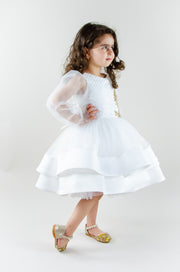 Short white flower girl dress with a multi-layer tutu skirt, transparent sleeves and 3D floral embroidery in gold. The dress is for weddings, birthdays, parties, flower girls and other special formal events and occasions.
