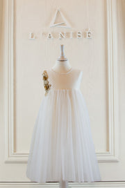 Knee-length white flower girl dress with empire silhouette, transparent mesh details and 3D floral embroidery in gold. The dress is for weddings, birthdays, parties, flower girls and other special formal events and occasions.