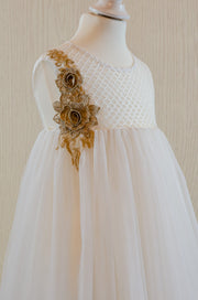 Knee-length white flower girl dress with empire silhouette, transparent mesh details and 3D floral embroidery in gold. The dress is for weddings, birthdays, parties, flower girls and other special formal events and occasions.