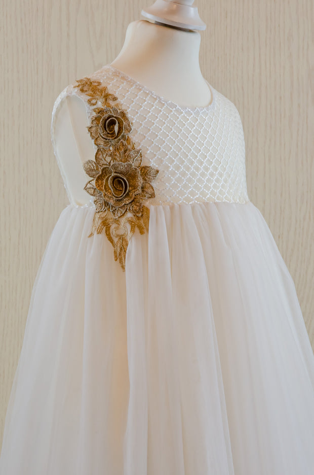 Knee-length white flower girl dress with empire silhouette, transparent mesh details and 3D floral embroidery in gold. The dress is for weddings, birthdays, parties, flower girls and other special formal events and occasions.