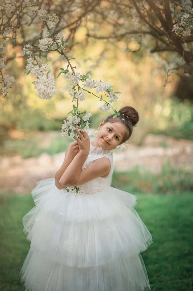 Ankle-length tulle girl dress with a multi-layered tulle skirt, tulle pleated top with a high collar and pearl embellishments along the neckline and the waistline.