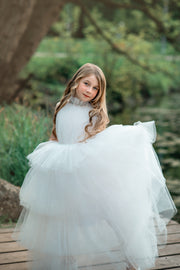 Ankle-length tulle girl dress with a multi-layered tulle skirt, tulle pleated top with a high collar and pearl embellishments along the neckline and the waistline.