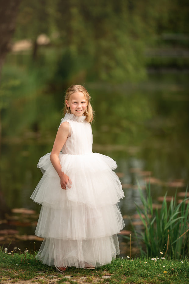 Ankle-length tulle girl dress with a multi-layered tulle skirt, tulle pleated top with a high collar and pearl embellishments along the neckline and the waistline.