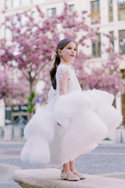 White, asymmetrical girl dress with a voluminous, ruffle tulle skirt, feather details and pearl embellished top. Occasions: Wedding, Birthday party, Flower girl, Communion, Eid and other events.