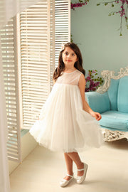 Knee-length white flower girl dress with empire silhouette, transparent mesh details and 3D floral embroidery in gold. The dress is for weddings, birthdays, parties, flower girls and other special formal events and occasions.