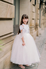 Long, white princess girl dress with a long, voluminous tulle skirt, embroidered top and big bows on the sleeves. For special occasions: flower girls, weddings, princess birthday party.