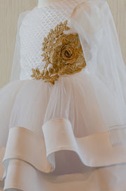 Handmade short white flower girl's dress with a multi-layered tutu skirt, golden embroidery and a big bow on the back