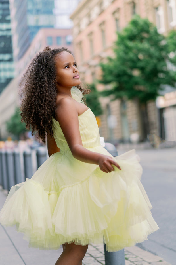 Knee-lenght bright yellow girl tutu dress with ruffles, asymmetrical pleated tulle top and a big 3D flower detail. For special occasions: Wedding, Birthday party, Prom, Flower girl, Eid, and other events.